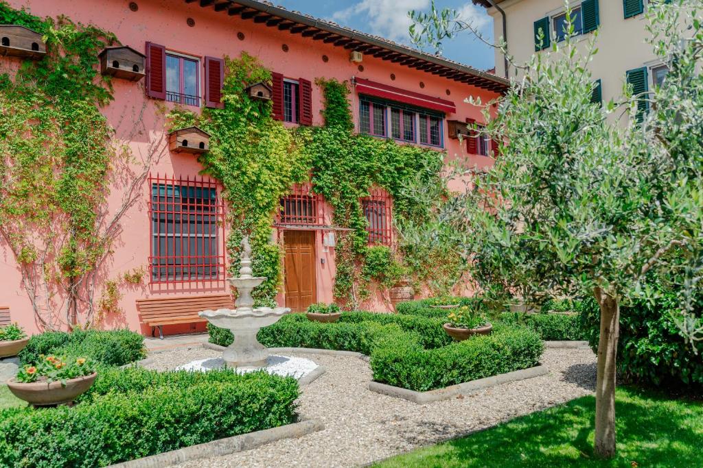 a garden in front of a pink building at I Palpiti - Dream Villa in Florence in Florence