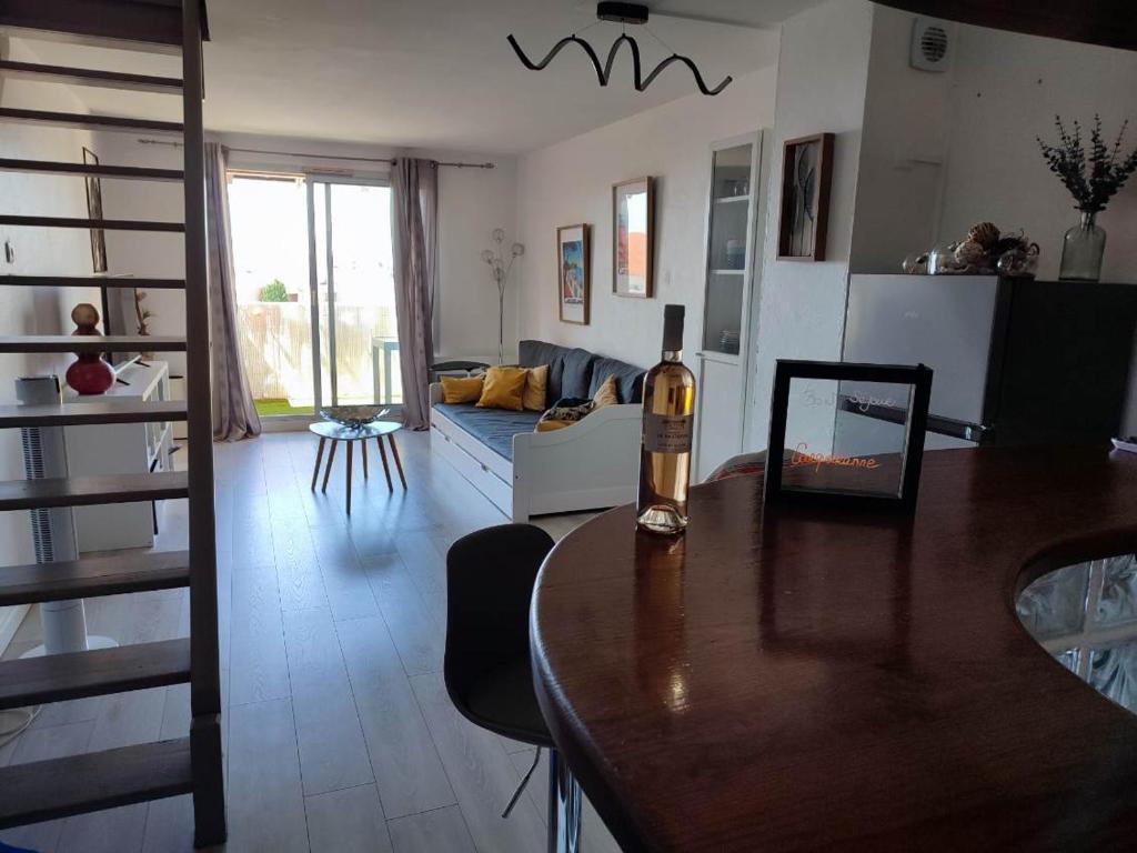 salon z butelką wina na stole w obiekcie Superbe appartement avec balcon vue mer ! w mieście Carqueiranne
