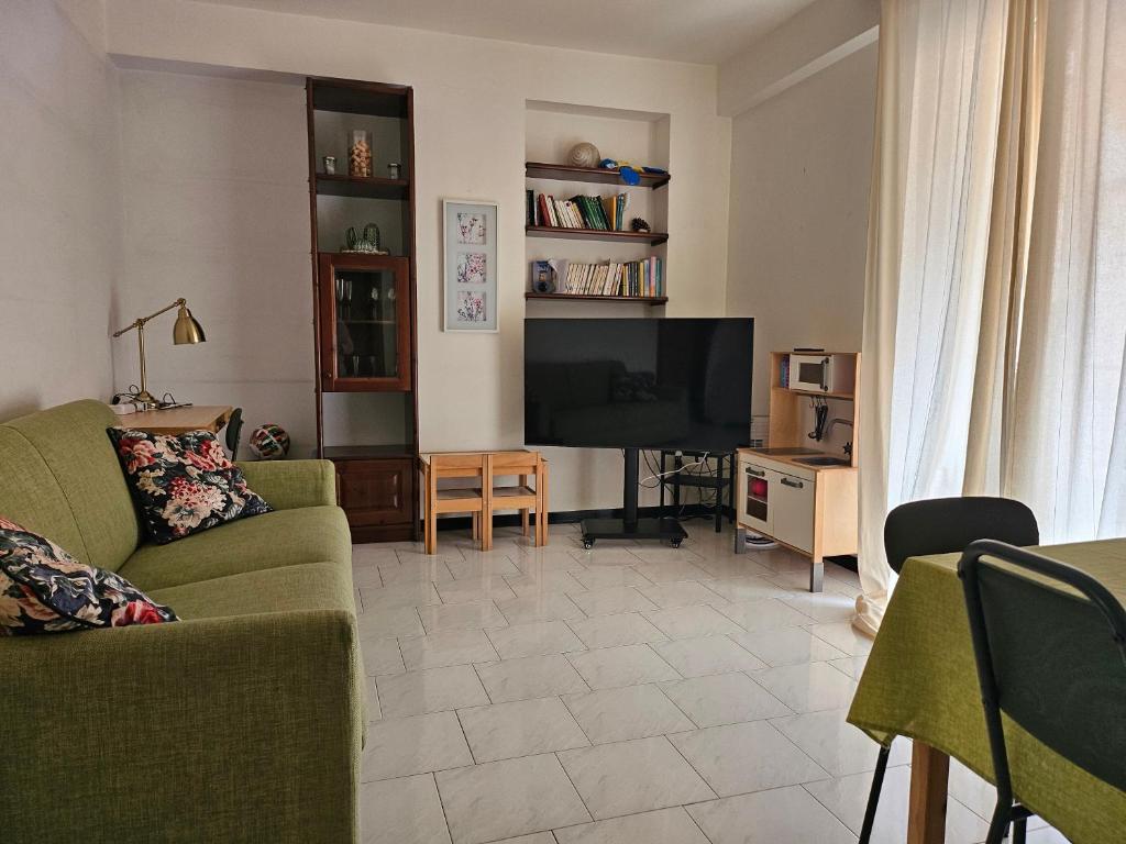 salon z kanapą i telewizorem w obiekcie Seaview Apartment by the Beach in Sicily w mieście Fondachello