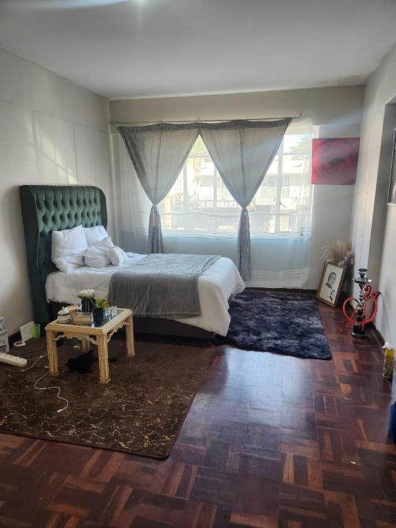 a bedroom with a bed and a table and a window at Beautiful View House in Vosburg