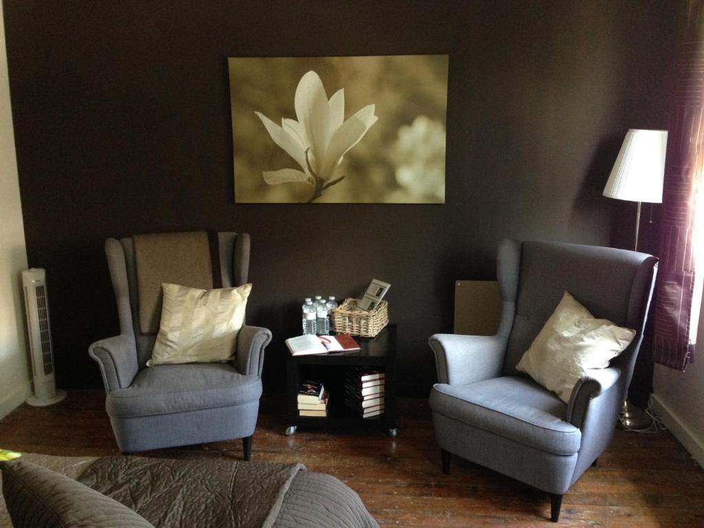 two chairs and a table in a living room at B&B Family@home66 in Bruges