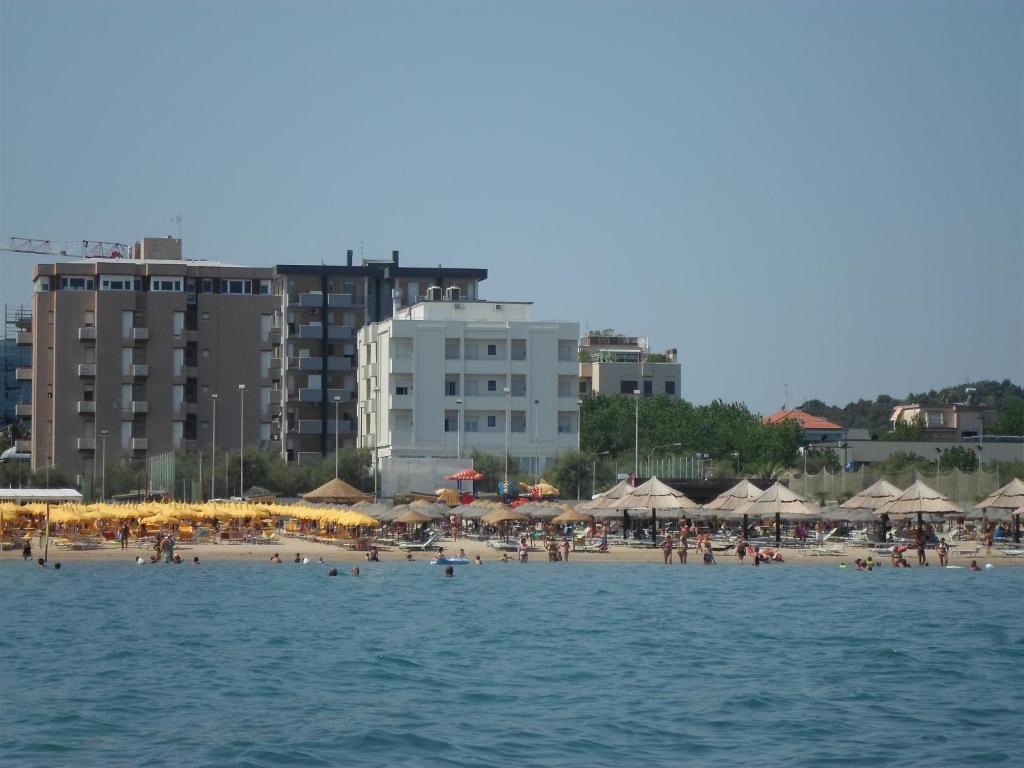 a beach with umbrellas and a crowd of people at Hotel Mare in Pesaro