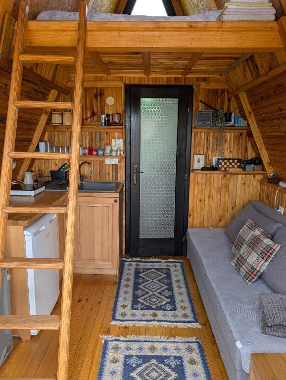 a room with a couch and a staircase in a cabin at A Pine vikendica u srcu Zapadne Srbije in Nova Varoš