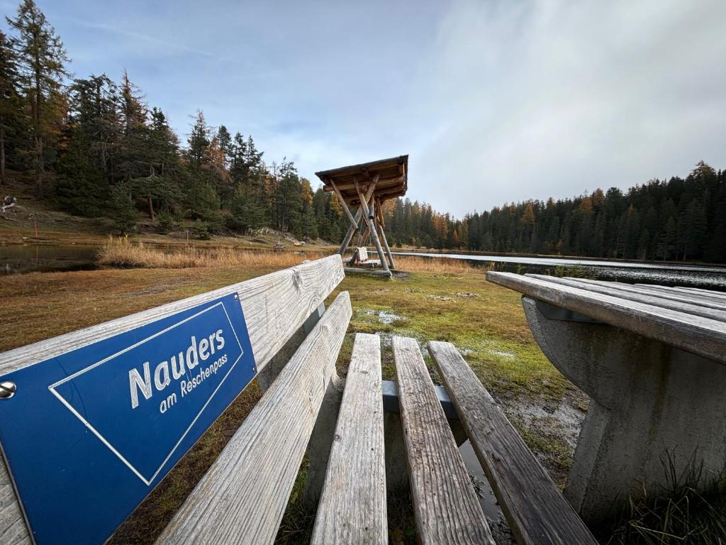 Un banco de madera con un cartel que dice nominacs en excitación en Abendruhe, en Nauders