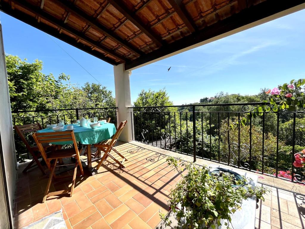 un patio avec une table et des chaises sur un balcon dans l'établissement MORIANI appartement cosy au coeur de la nature, à San-Nicolao