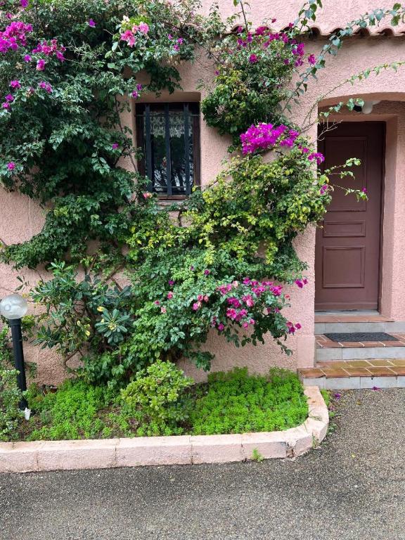 un bâtiment avec des fleurs sur son côté dans l'établissement Maison PORT FREJUS, à Fréjus