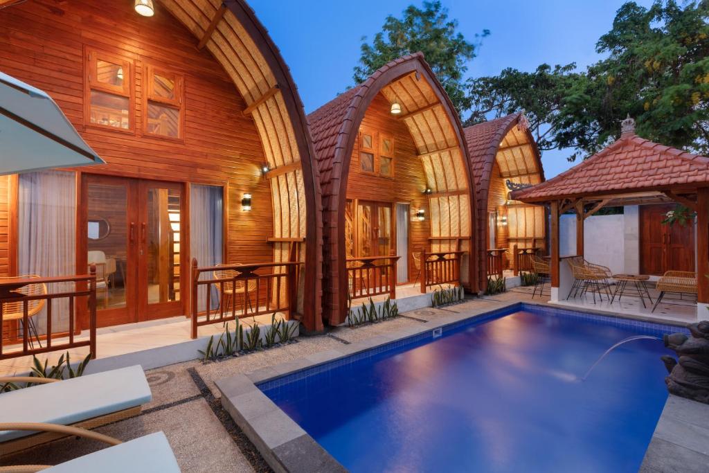 une maison avec une piscine en face d'un bâtiment dans l'établissement Luh Adi Villa 1, Balinese Wooden House in Uluwatu, à Uluwatu