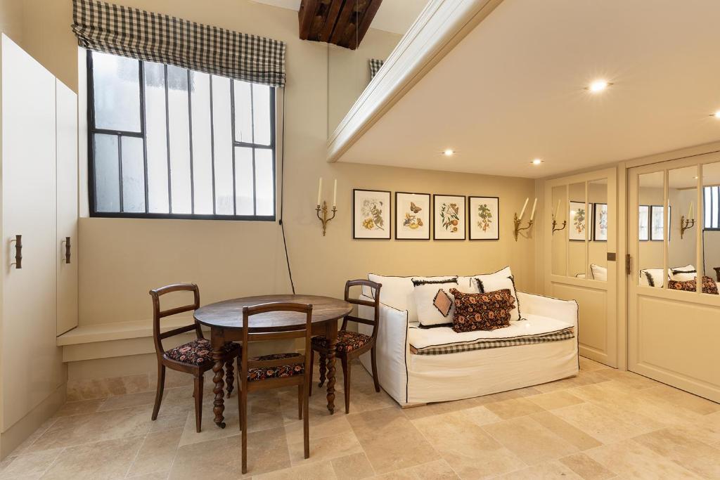 un salon avec une table et un canapé dans l'établissement Pick A Flat's House in Saint-Germain des Près - Impasse Paul Louis Courier, à Paris