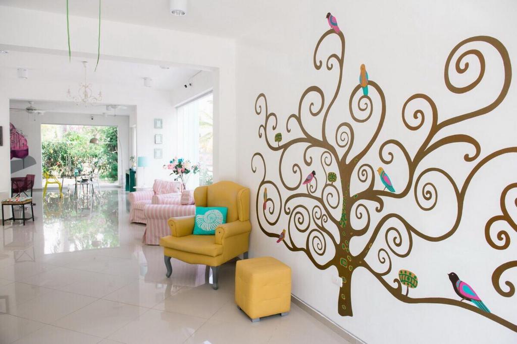 a living room with a tree mural on the wall at Art Villa Dominicana in Punta Cana