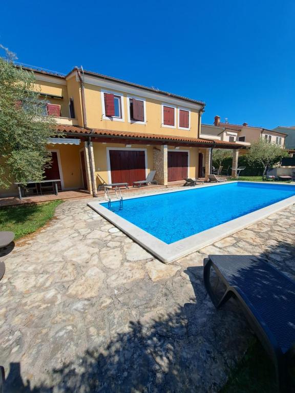 a house with a swimming pool in front of it at Apartment Oliva Volme in Banjole