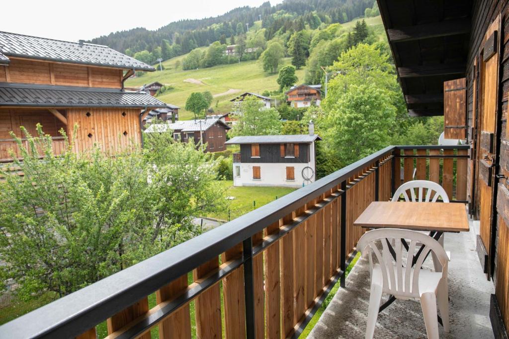 - un balcon en bois avec une table et des chaises dans l'établissement Studio 3 personnes Chalet Tournier, aux Gets