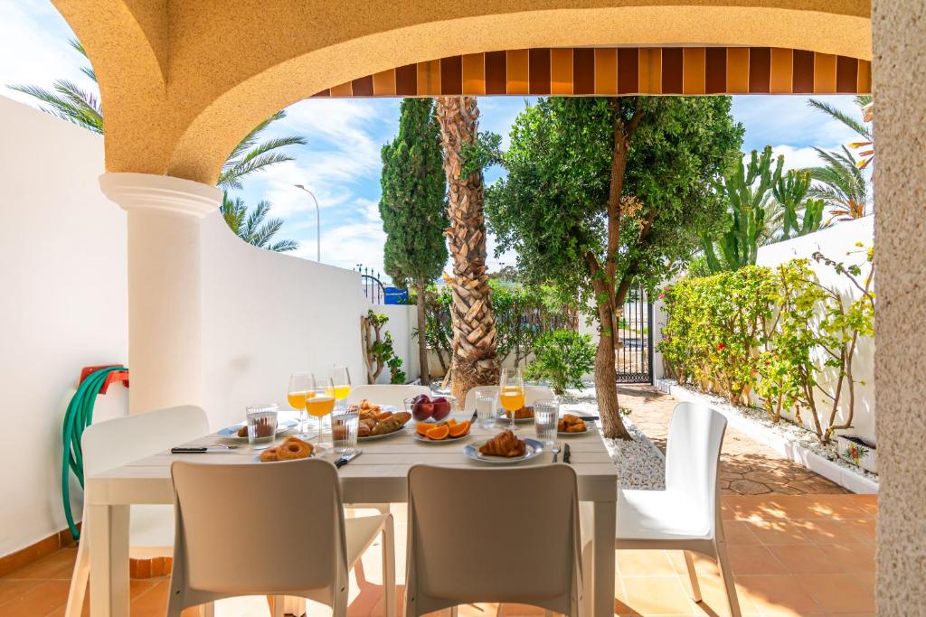 einen Tisch mit Speisen und Getränken auf einem Balkon mit Palmen in der Unterkunft Duplex de 3 habitaciones en Terreros - By Aloha Palma in San Juan de los Terreros