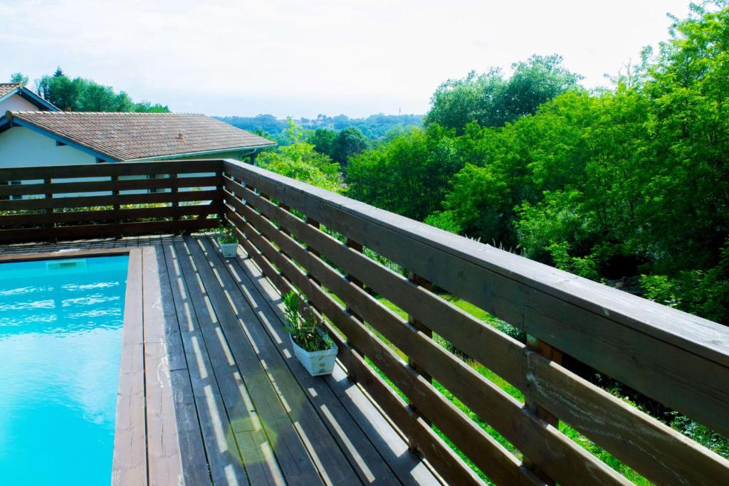 une terrasse en bois avec une piscine et une clôture dans l'établissement Spacious house with pool in Ondres, à Ondres