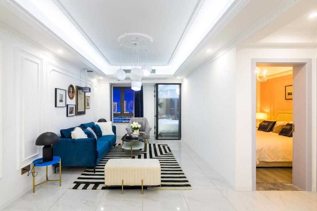 a living room with a blue couch and a bed at 云深处江景公寓 in Chongqing