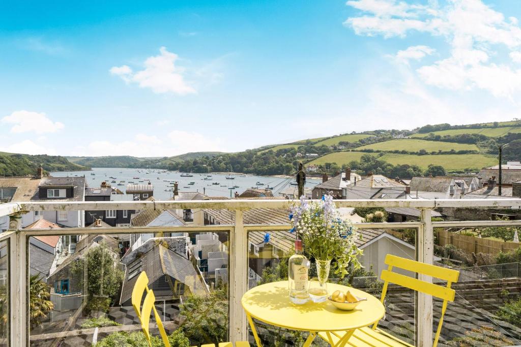 balcón con mesa amarilla, sillas y vistas en Monkey's Fist, en Salcombe