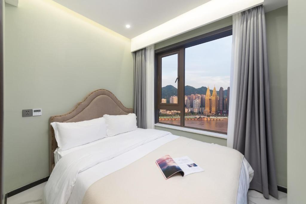 a bedroom with a bed and a large window at 云深处江景公寓 in Chongqing