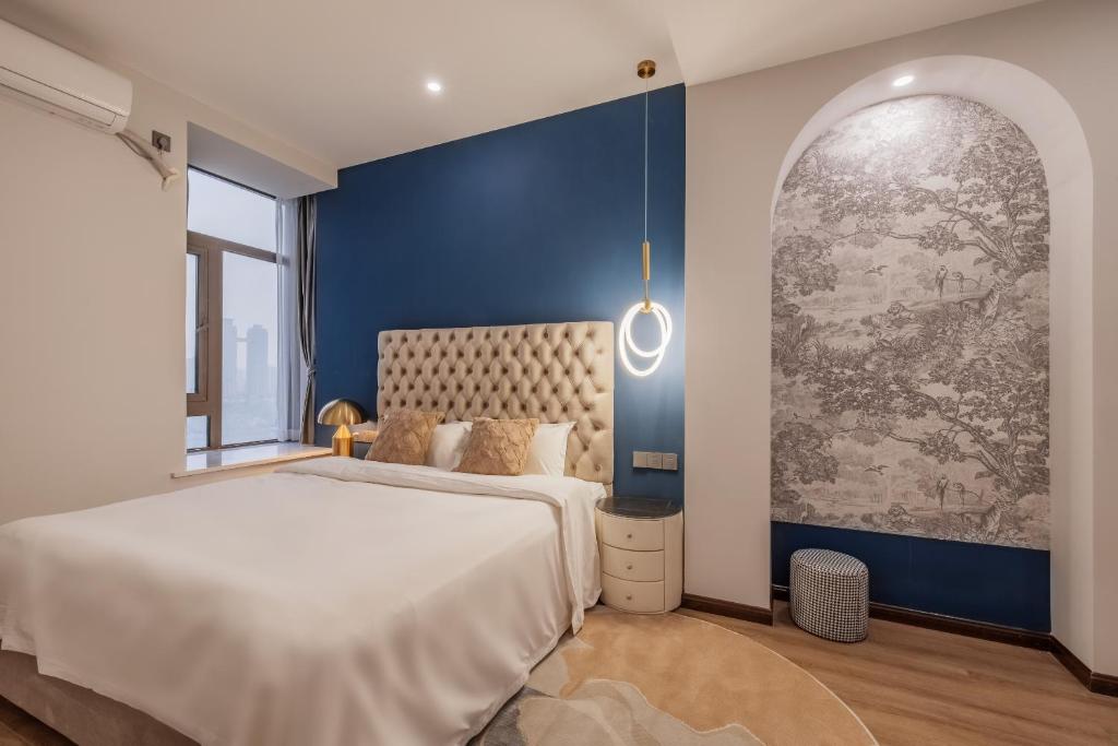 a bedroom with a white bed and a blue wall at 云深处江景公寓 in Chongqing