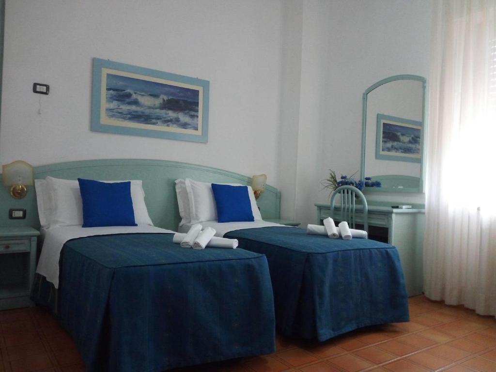 two beds in a room with blue and white at Hotel Mercede 2 in San Felice Circeo