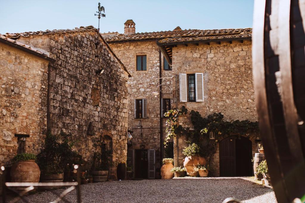 an old stone building with a gate in front of it at Fattoria San Donato in San Gimignano