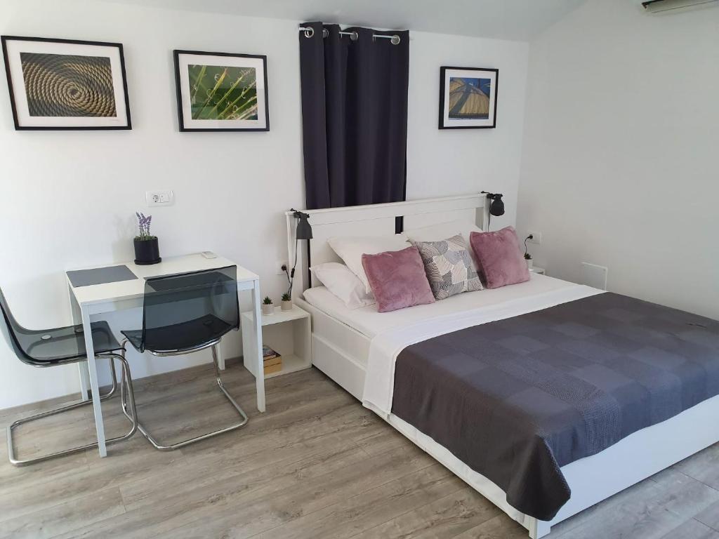 a bedroom with a bed and a desk and a desk at Slatki kut in Vis