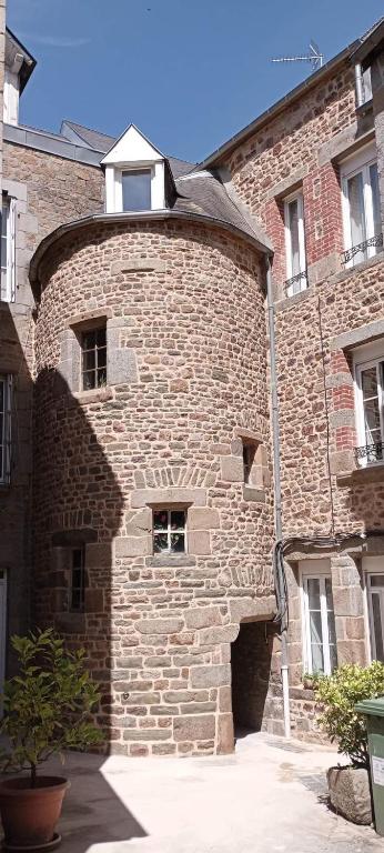 un bâtiment en briques avec une fenêtre au-dessus dans l'établissement Gîte La cour des trois rois 2, à Villedieu-les-Poêles
