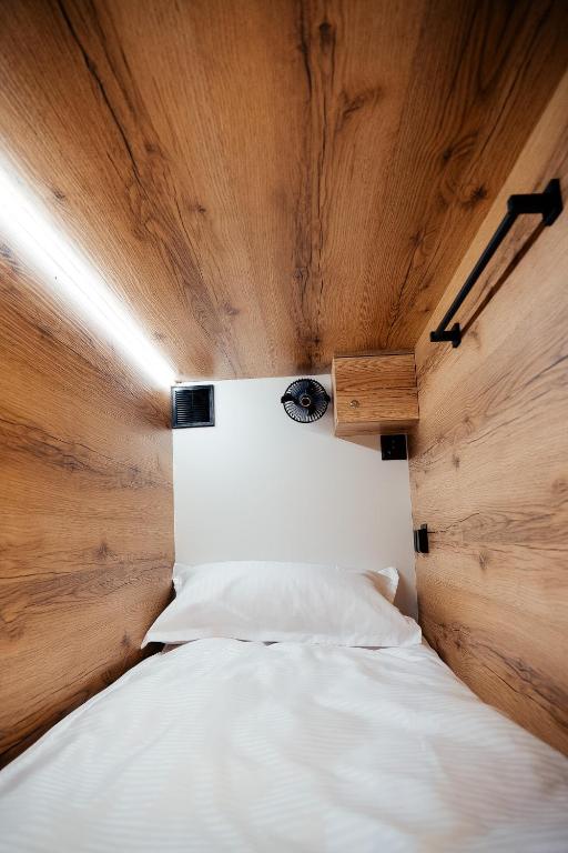 a bedroom with a white bed with a wooden ceiling at Хостел 1377 in Astana