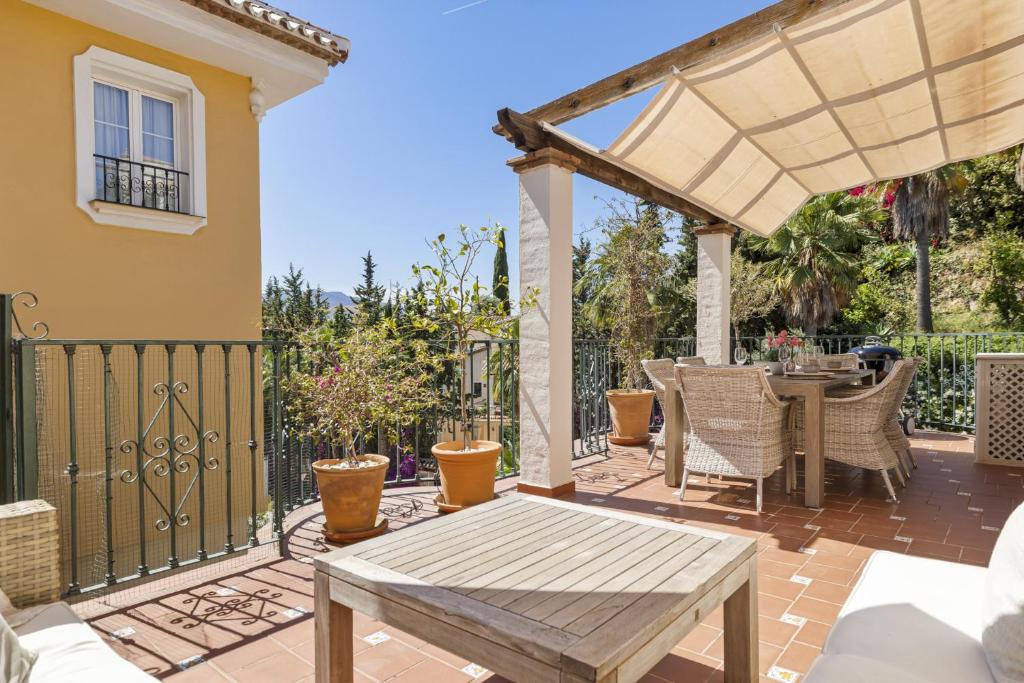 a patio with a wooden table and a pergola at Golf Residence Casa Aida in Mijas