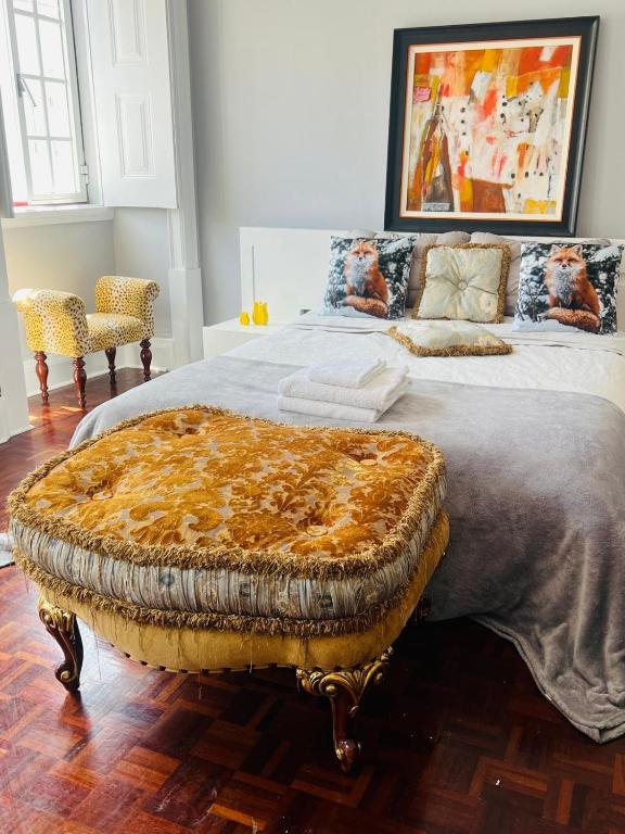 a bedroom with a large bed with an ottoman at Casa Amore in Montemor-o-Velho