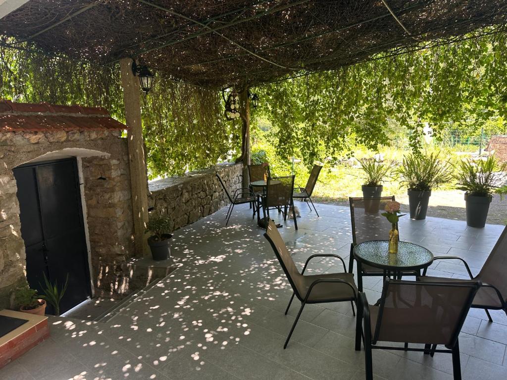 a patio with tables and chairs and a fireplace at Etno village Mihailovic in Herceg-Novi