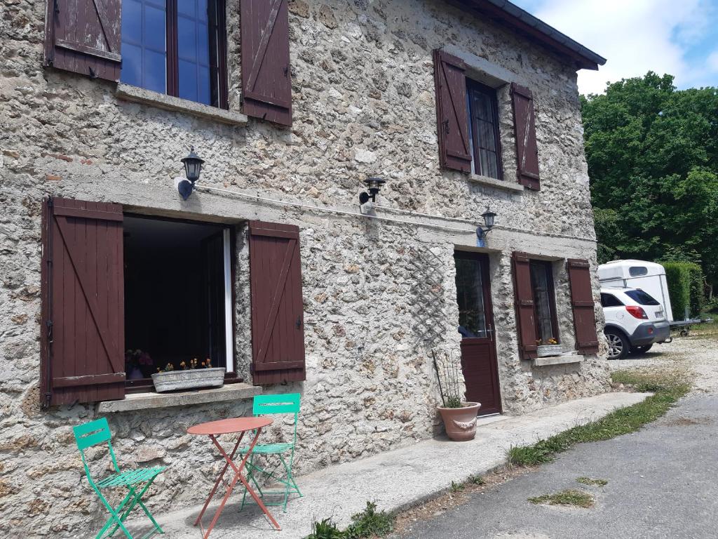 - un bâtiment en pierre avec deux chaises et une fenêtre dans l'établissement Gite du Paradis, à Belval-sous-Châtillon