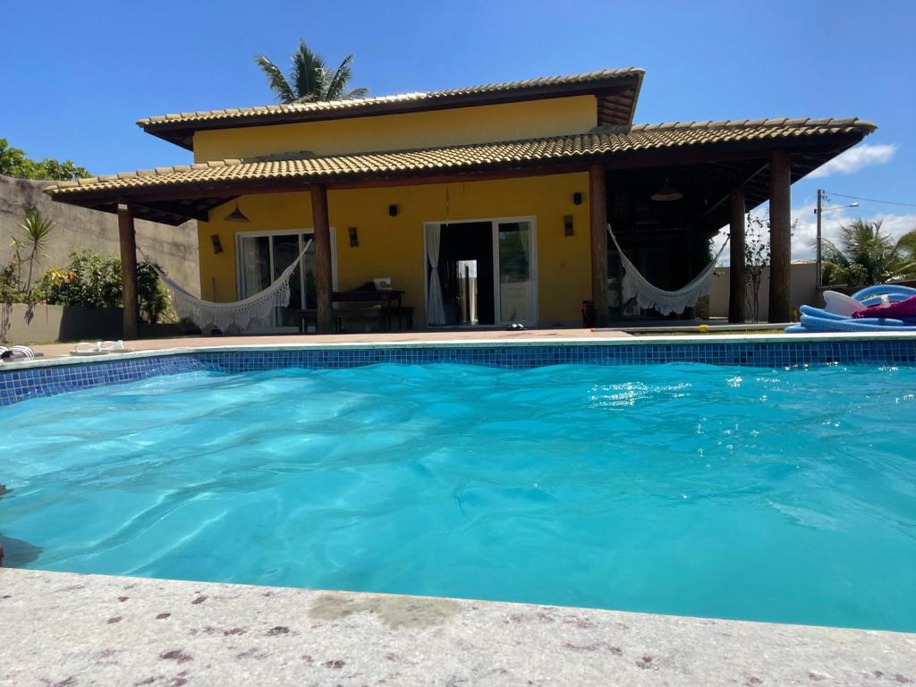 a villa with a swimming pool in front of a house at Jacuipe beach house in Camaçari