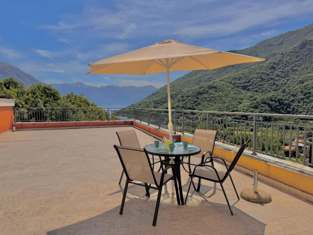 a table and chairs with an umbrella on a patio at Lavender Bay Apartment D9 in Donji Morinj