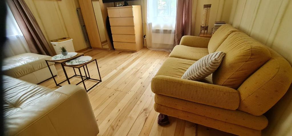 a living room with a couch and two chairs at Poilsis Juodkrantėje in Juodkrantė