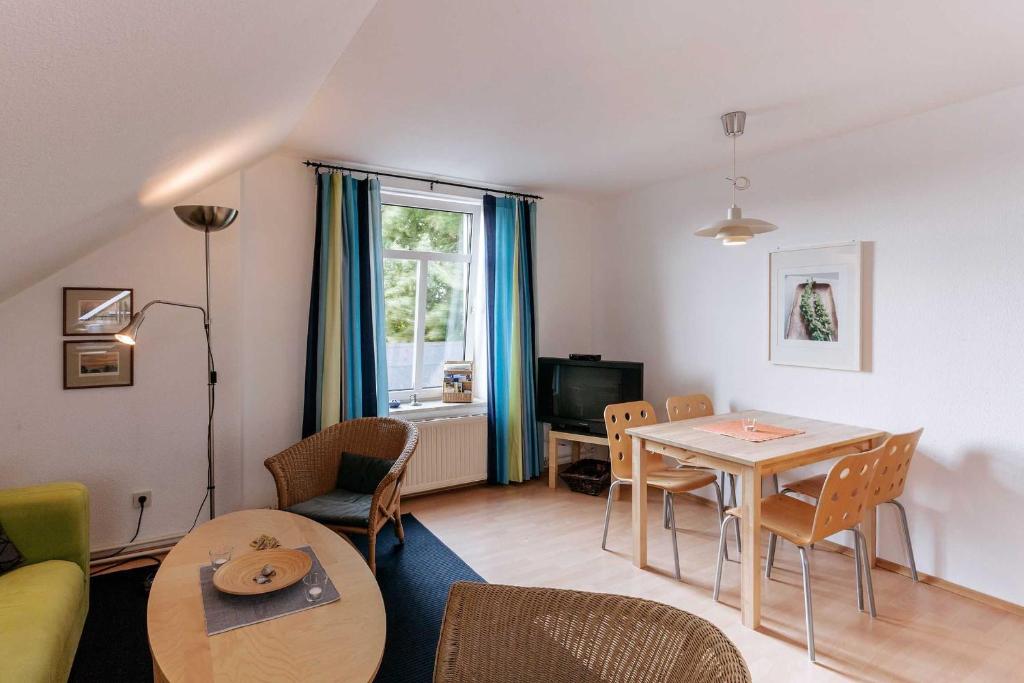 a living room with a table and a dining room at Ferienwohnung Alter Dorfkrug 2 in Kronsgaard