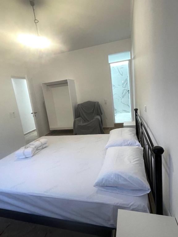 a bedroom with two beds and a chair in it at Oikos Corfu in Alepou