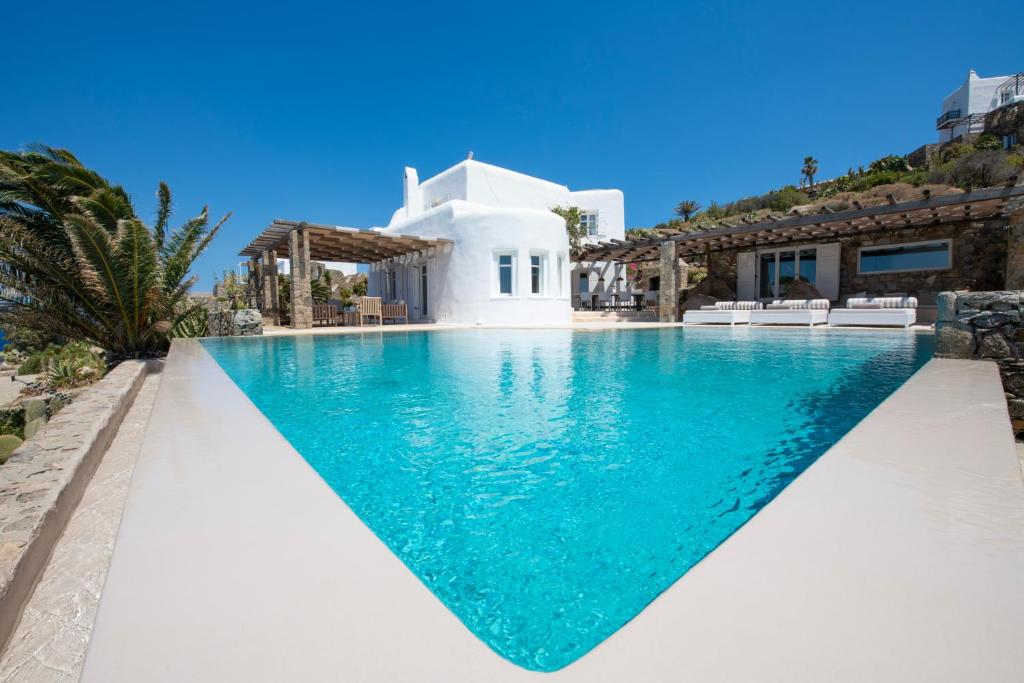 a swimming pool in front of a villa at Topos exclusive Mykonos in Agios Ioannis Mykonos