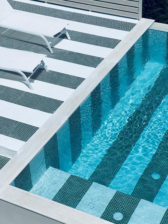 an overhead view of a swimming pool with blue water at Georgianna's suite with private pool , 'blank suite' in Kharokopión