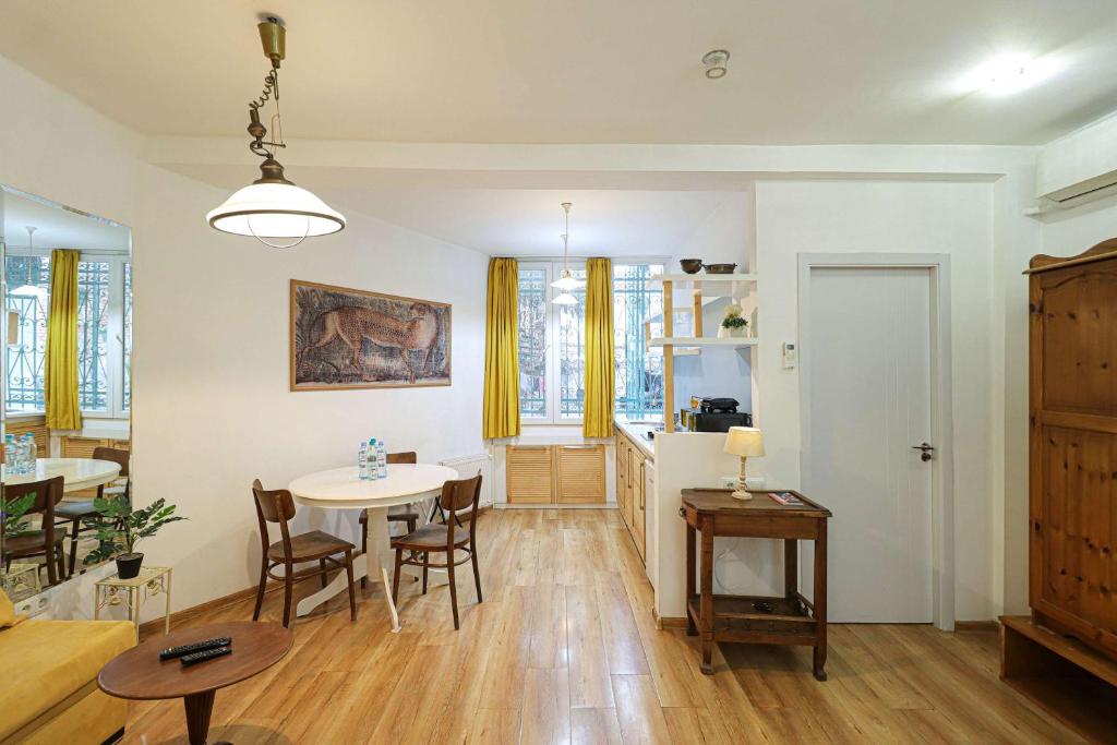 Una sala de estar con una mesa y un comedor. en Wehost Heart Of Tbilisi Studio, en Tiflis