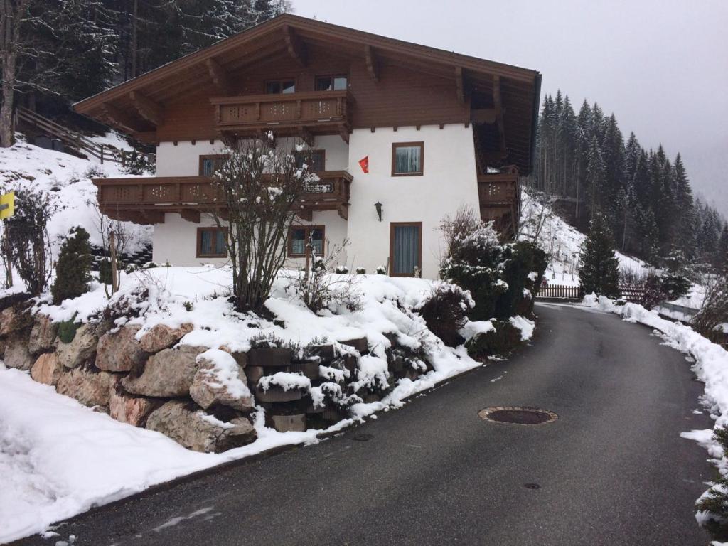 ein Haus auf einer schneebedeckten Straße neben einem Berg in der Unterkunft Haus Schartner in Daar