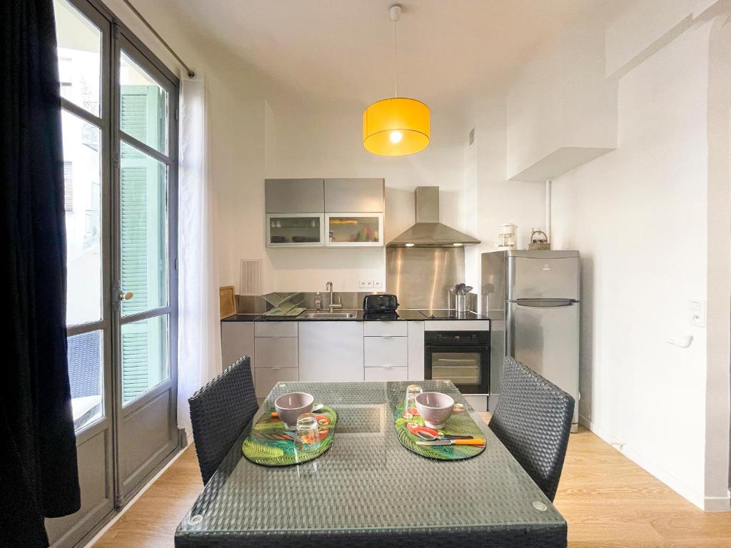 une cuisine avec une table avec deux assiettes dessus dans l'établissement Le Comte De Nice 2 Pers Centrale AC WiFi, à Nice