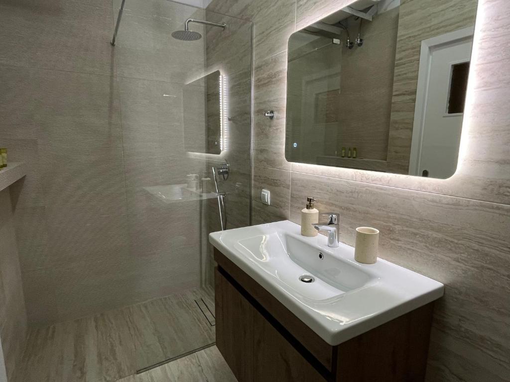 un baño con lavabo y espejo en J&N Living, en Spáta