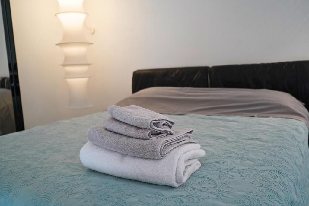 una pila di asciugamani appoggiata sopra un letto di Lumiae Suite a Lecce