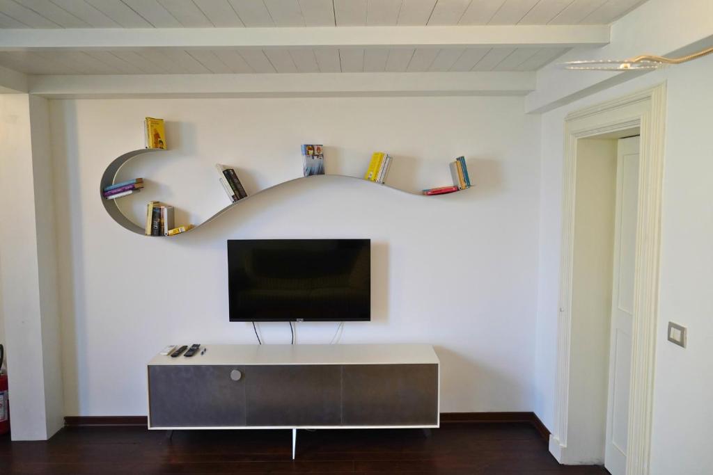 un soggiorno con una TV a parete di Lumiae Suite a Lecce