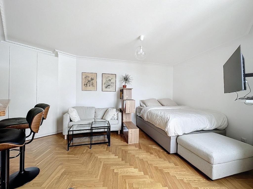une chambre avec un lit, une télévision et une chaise dans l'établissement Paris 8 Madeleine beauty, à Paris