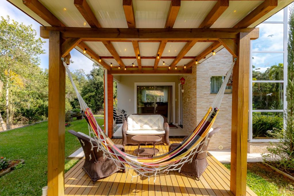 Benedito NovoにあるCasa de campo c Wi-Fi, jardim e churrasqueiraのデッキ(パーゴラ付)のハンモック