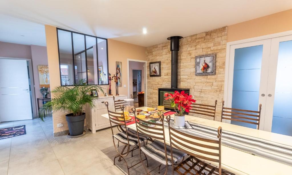 ein Esszimmer mit Tisch und Kamin in der Unterkunft La bourbonnaise in Corme-Royal