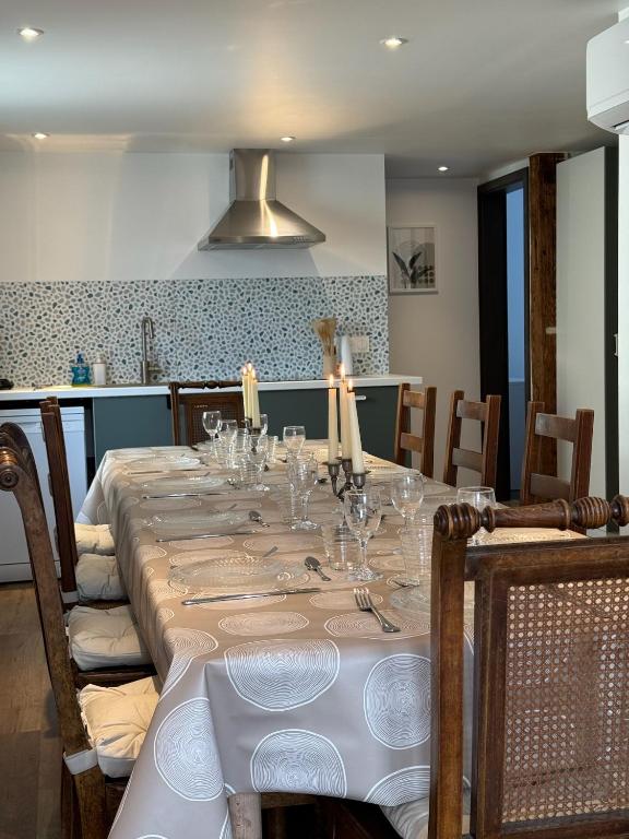 - une salle à manger avec une longue table et des verres dans l'établissement Maison Alsacienne Centre Alsace, à Hilsenheim