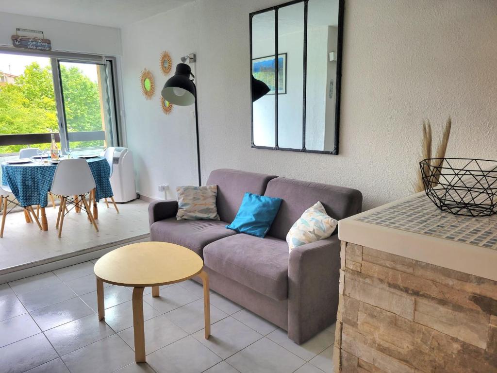 un salon avec un canapé et une table dans l'établissement Grand studio cabine 4 personnes Clim Très bien situé, au Cap d'Agde