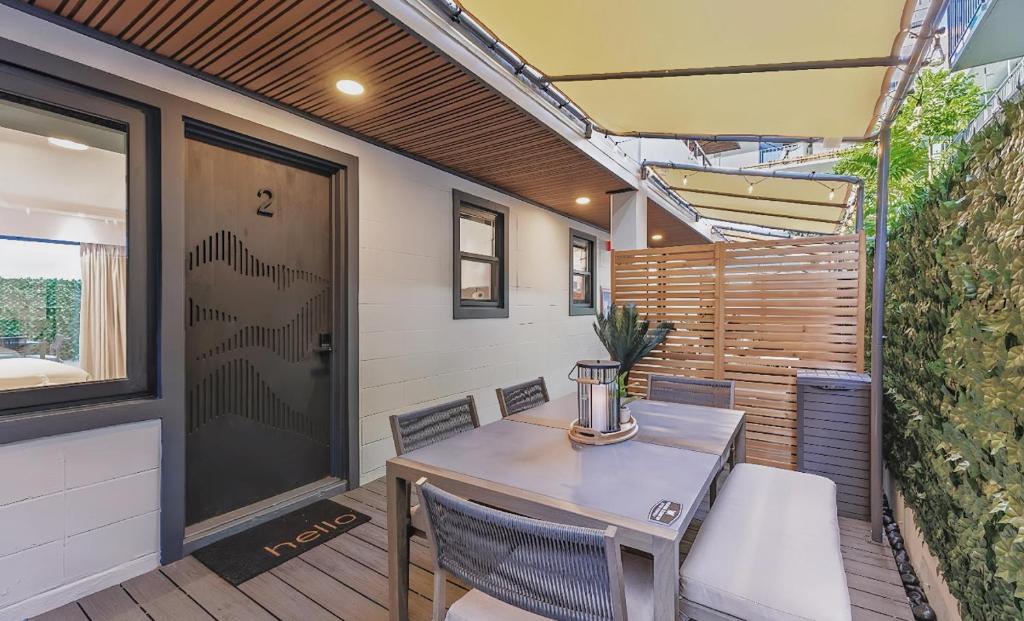 a patio with a table and chairs and a door at The Walk-Up Waikiki Beach in Honolulu