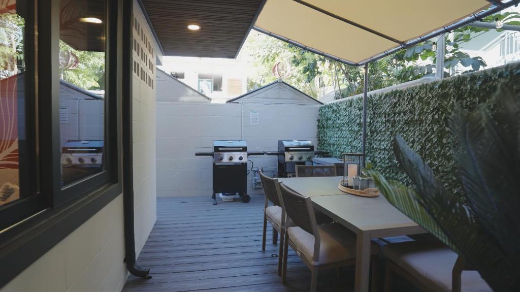 a patio with a table and chairs and a grill at The Walk-Up Waikiki Beach in Honolulu